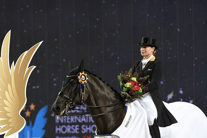 Isabell Werth en una entrega de premios con un caballo negro en 2018