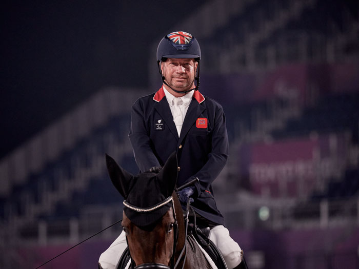 Lee Pearson, jinete paralímpico de grado III, montando a su caballo Breexzer en la pista de competición de Tokio 2020